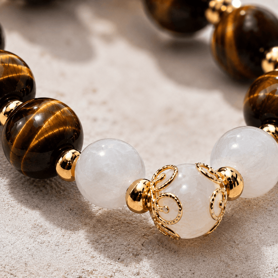 Tiger's eye and moonstone beaded bracelet with gold accents on sand